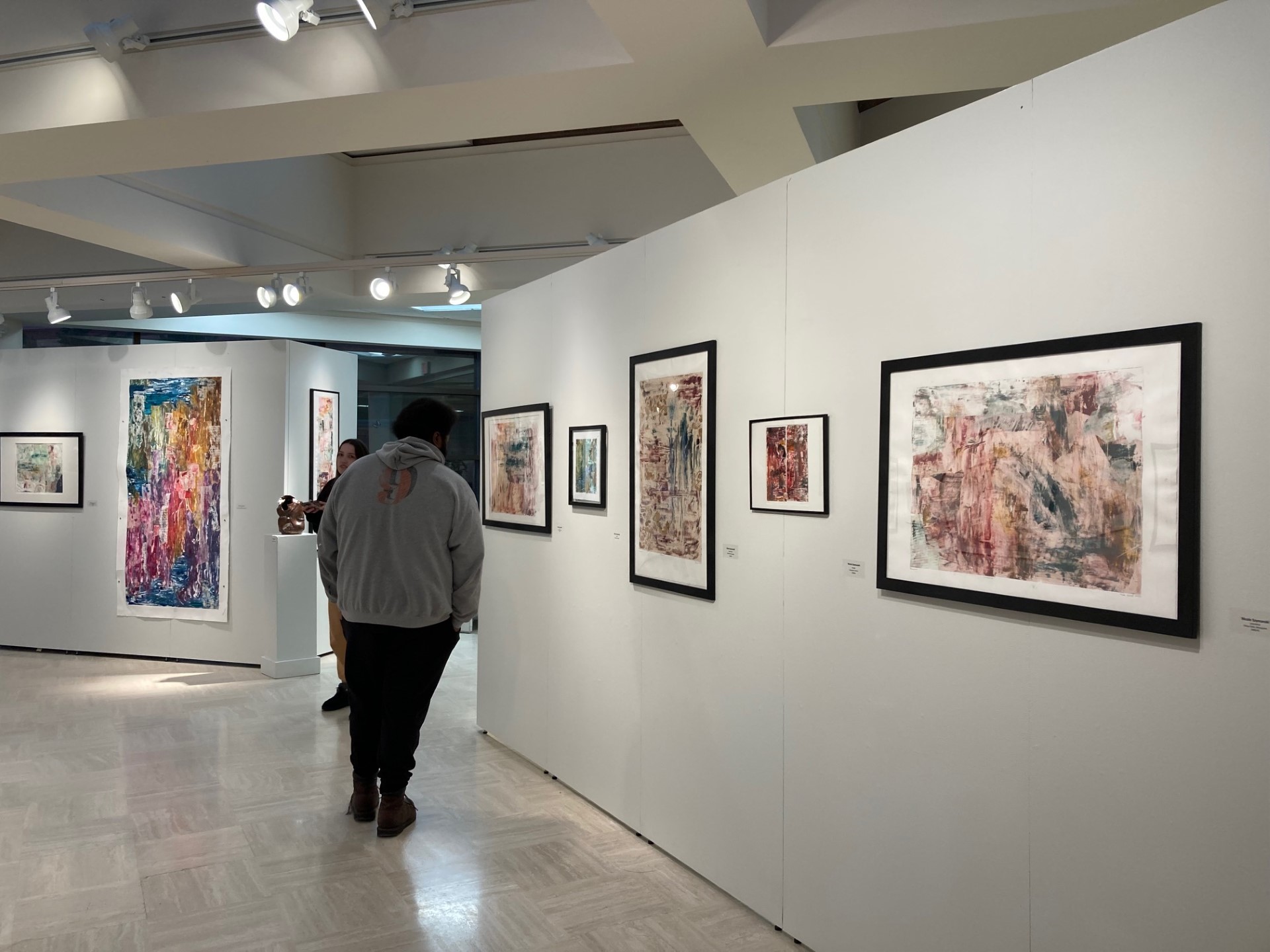 Viewers looking at szymanski works on paper center gallery looking south
